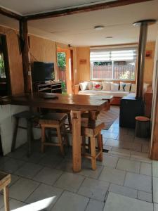 a living room with a wooden table and a couch at Casa Claudia in Pucón
