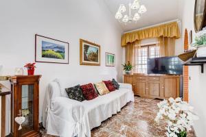 uma sala de estar com um sofá branco e uma televisão em Villa Marisol em Cesano