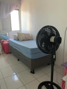 um quarto com uma cama e uma ventoinha num tripé em Ape em Maceió em Maceió