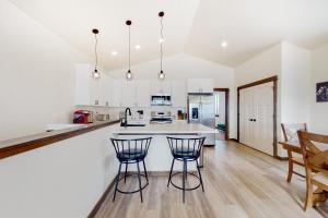 a kitchen with white cabinets and a counter with two bar stools at Spanish Peaks 4 in Belgrade