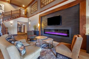 sala de estar con chimenea y TV en Best Western Premier Bridgewood Hotel Resort, en Neenah