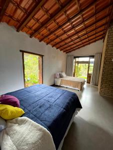- une grande chambre avec 2 lits et une grande fenêtre dans l'établissement Casa Mirante do Capão, à Palmeiras