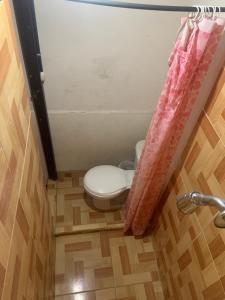 a bathroom with a toilet and a shower curtain at Hostel Casa María in Masaya