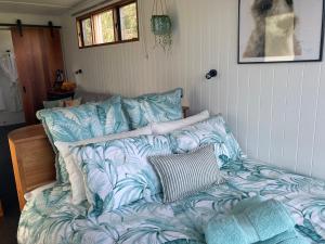 a bed with blue and white sheets in a room at Stephanie’s Country Cottages in Drummond