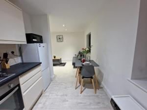 a kitchen with a table and a dining room at zDNU 2 Bedroom Apartment ReeAni Stays in Uxbridge +4 photos