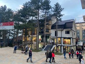 eine Gruppe von Menschen, die vor einem Gebäude spazieren gehen in der Unterkunft Apartman Jolić in Zlatibor