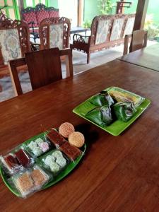 two plates of food on a wooden table at Pendopo Kayuwanan Homestay Syariah in Yogyakarta