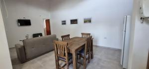 a dining room with a table and chairs and a couch at ALQUIFE, complejo de departamentos in Capilla del Monte