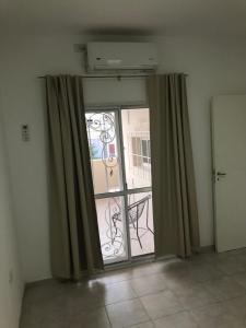 Habitación con ventana con cortinas y balcón. en Junin dptos 1 en San Fernando del Valle de Catamarca