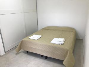 a small bed in a room with two towels on it at Junin dptos 1 in San Fernando del Valle de Catamarca