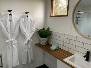 a bathroom with white towels hanging on a wall at Stephanie’s Country Cottages in Drummond