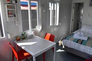 1 dormitorio pequeño con 1 cama, mesa y sillas en Container Departamento en Puerto Natales, en Puerto Natales