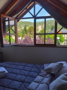 a bedroom with a bed and a large window at Instantes in San Martín de los Andes