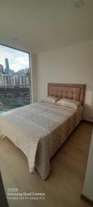 1 dormitorio con 1 cama grande y ventana grande en Apartamento Urapanes La Toscana, en Manizales