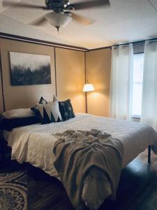um quarto com uma cama e uma ventoinha de tecto em The Towner Cozy country home Red River Gorge em Stanton