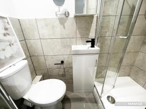 y baño pequeño con aseo y ducha. en Erin Court Mansion - RM 11 en Croydon