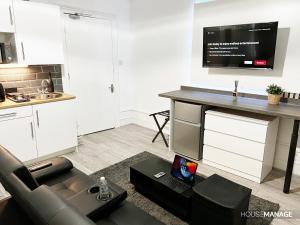 uma sala de estar com um sofá e uma mesa com uma televisão em Erin Court Mansion - RM 11 em Croydon