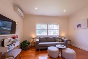 un soggiorno con divano e TV di Campbells Cottage by Ready Set Host a Frankston