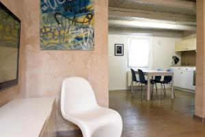 uma sala de estar com uma cadeira branca e uma mesa em La Piccola Casa di Via Ricotti em Castelguglielmo