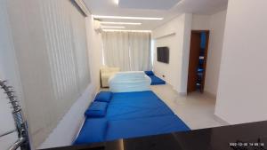 um quarto de hospital com uma cama azul num corredor em Casa com piscina e hidromassagem praia Enseada. no Guarujá