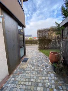 a brick walkway next to a building with a door at ALB-APARTMENT-WESTERHEIM Kurort in Westerheim