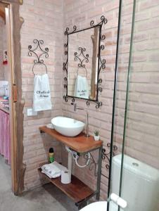 La salle de bains est pourvue d'un lavabo et d'un miroir. dans l'établissement Chalés de Hórus, à São Thomé das Letras