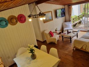 a living room with tables and chairs and a balcony at Casas Pamelas in Algarrobo