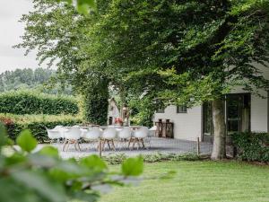 een groep witte stoelen en een tafel in een tuin bij Spacious holiday home in Leende with garden in Leende