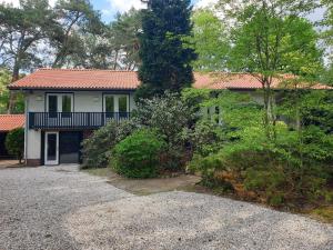 a white house with a red roof and a driveway at Stylish holiday home in Leende with garden in Leende