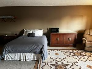 Beaver CityにあるFurnas County Lodgingのベッドルーム1室(ベッド1台、デスク、椅子付)