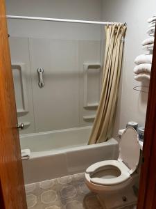 a bathroom with a toilet and a shower at Furnas County Lodging in Beaver City