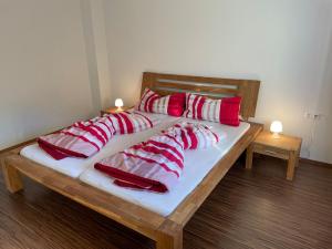 a bed with red and white pillows on it at Ferienwohnung Bernhardiner in Nauders