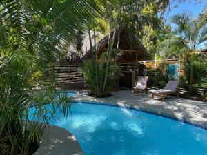 a resort with a swimming pool and a house at Anam Apartments in Santa Teresa Beach