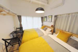 a bedroom with two beds with yellow and white sheets at Sumida Ward - House - Vacation STAY 89031 in Tokyo