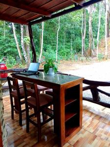 a wooden table with a laptop on a patio at Cabaña Eco-Arte in Tortugal +37 photos