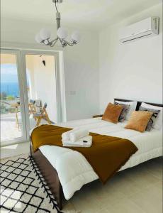 a bedroom with a large bed and a balcony at DDM Studio - O paraíso do Sítio da Nazaré in Nazaré