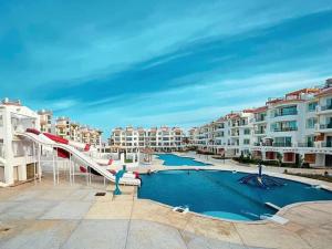 a swimming pool with a slide and some buildings at Sharm Hills Resort - 2Bedroom with Pool View and Beach Access in Sharm El Sheikh