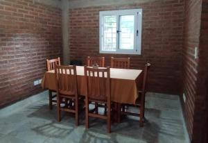 a dining room with a table and chairs and a window at Temporario Jujuy Campo in Lozano