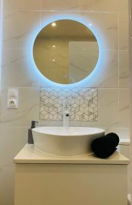 La salle de bains est pourvue d'un lavabo blanc et d'un miroir. dans l'établissement Flat on 2 floors near stade de france, à Aubervilliers