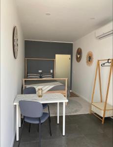 een kamer met een tafel en stoelen en een bed bij DDM Studio - O paraíso do Sítio da Nazaré in Nazaré