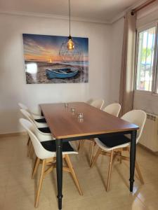 マサロンにあるDroomvilla, complete private villa met privaat zwembadのダイニングテーブル(白い椅子付)