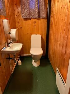 a bathroom with a toilet and a sink at Macktunet - Retro log cabin from the 70s in Malangen 