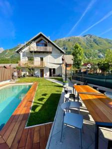 uma villa com uma piscina e uma casa em Emerald Valley Apartments em Bovec