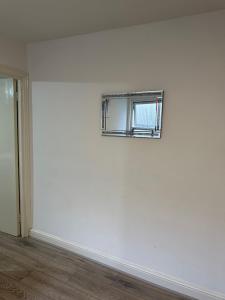 uma parede branca com uma janela num quarto em Beautiful First Floor one bedroom apartment B Walthamstow em Londres