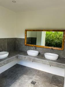 a bathroom with three sinks and a mirror at Red Picnic Hostel in Panglao