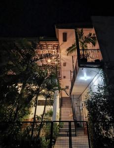 ein Gebäude in der Nacht mit Palmen davor in der Unterkunft Green Turtle Backpackers Guesthouse, Puerto Princesa in Puerto Princesa
