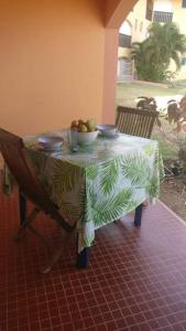 un tavolo con un cesto di frutta sopra di My Tiny Caritan- Petit coin de paradis- Bungalow de vacances- jardin, plage, piscine attenante a Sainte-Anne