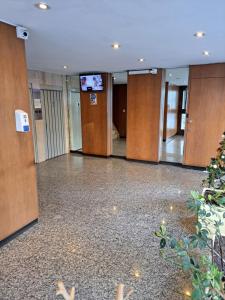 un vestíbulo vacío con puertas de madera y TV en Departamento Plaza España con Wifi en Mar del Plata