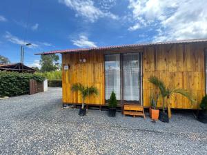 a wooden house with plants in front of it at Glamping en villa in Villa de Leyva