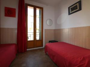 1 dormitorio con cama roja y ventana en Appartement Collioure, 4 pièces, 6 personnes - FR-1-309-213 en Collioure